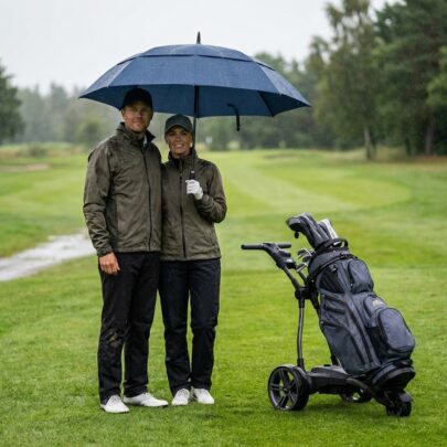 stort paraply för två i regn på golfbana